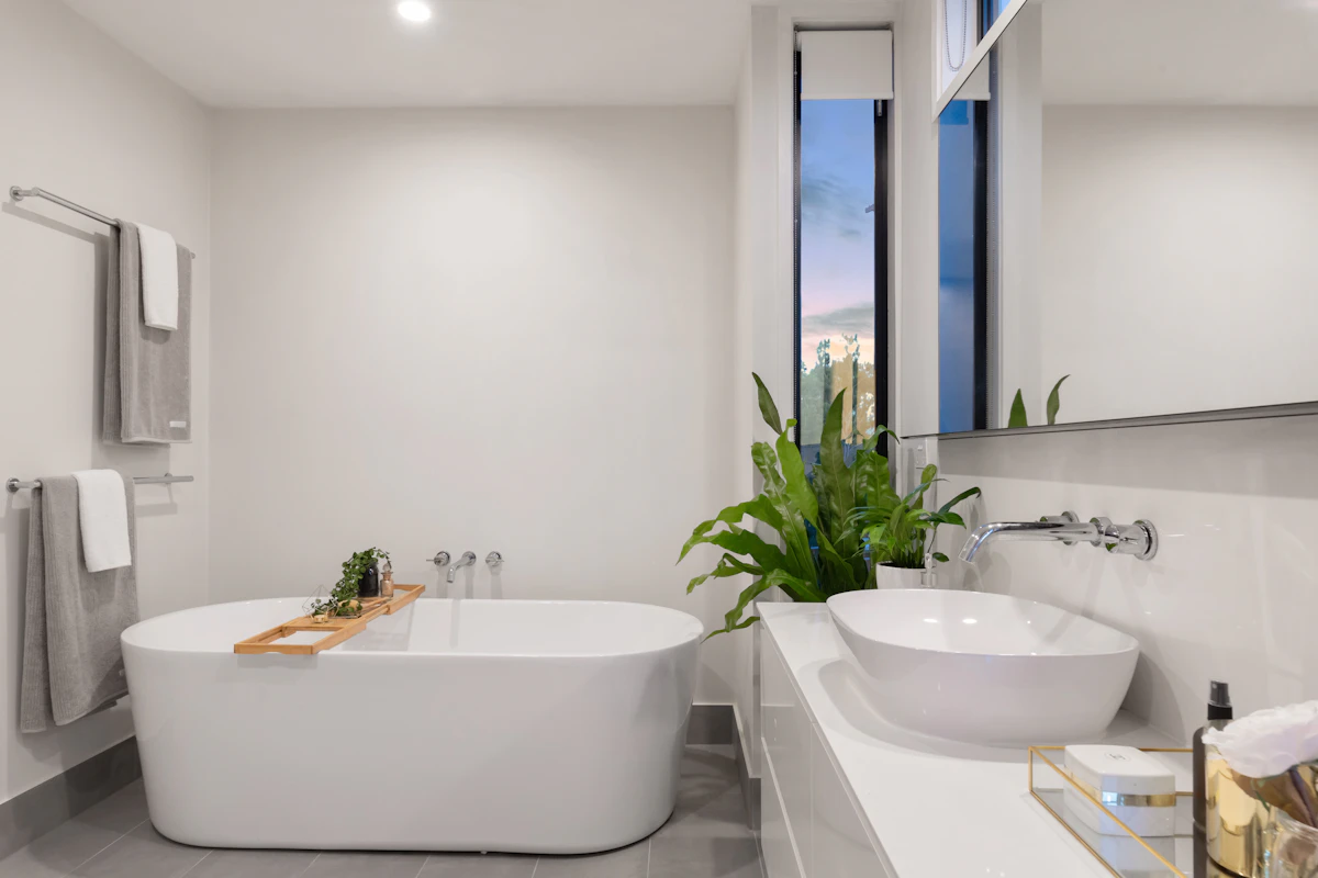 Bright bathroom with a bath, washbasin and hanging towels