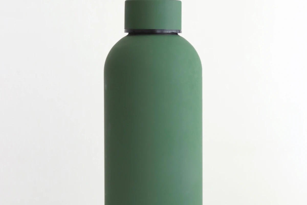 Green reusable water bottle against a plain background